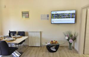 Zimmer mit 2 Tischen und einem TV an der Wand in der Unterkunft Komfortable Wohnung in Savudrija mit Grill, Garten und Terrasse in Savudrija + 14 Fotos