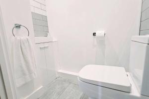 a white bathroom with a toilet and a shower at Oakdale at Weavers Yard No2 in Farnham