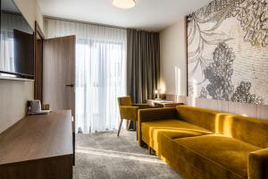 a hotel room with a yellow couch and chairs at Dom Wczasowy Zew Morza in Jastrzębia Góra