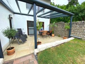 eine Pergola mit einem Tisch und Stühlen auf einer Terrasse in der Unterkunft Helle Ferienwohnung in Oberfellendorf mit Terrasse, Grill und Garten in Oberfellendorf