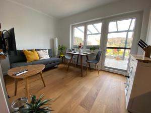 ein Wohnzimmer mit einem Sofa und einem Tisch in der Unterkunft Helle Ferienwohnung in Oberfellendorf mit Terrasse, Grill und Garten in Oberfellendorf