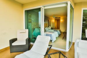 1 habitación con sillas blancas y 1 habitación con 1 dormitorio en Departamento a pie de playa, en Nuevo Vallarta 