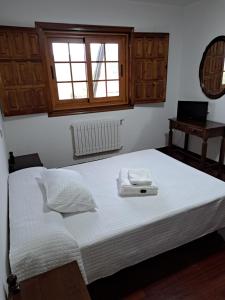 1 cama con 2 toallas en un dormitorio en Hostal - Restaurante Casa Cuña, en Tebra