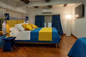 a bedroom with a bed with a blue and yellow blanket at Two Rooms Chiaia 37 in Naples