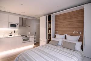 1 dormitorio blanco con 1 cama grande y cocina en Apartamentos Casalarreina, en Casalarreina