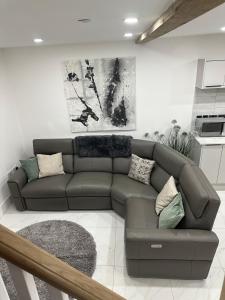 a living room with a brown couch in a kitchen at Lewys Ty Bach in Aberaman