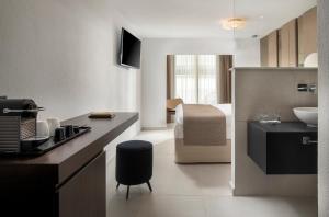 uma cozinha com um balcão e uma sala com um lavatório em Alexandrion Appartements Down Town em Sarti