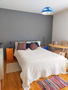 1 dormitorio con cama blanca y mesa en Casa Anita In centro, en Palermo