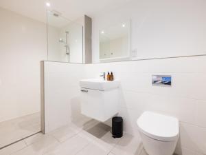 a white bathroom with a toilet and a sink at Epphaven in Polzeath +6 photos
