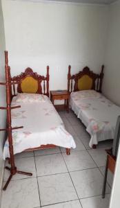 ウベルランジアにあるPousada Econômicaのベッド2台とテーブルが備わる客室です。