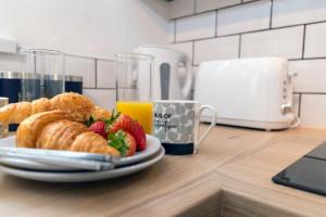 a plate of croissants and strawberries and a cup of orange juice at Jameson Lodge in Hartlepool