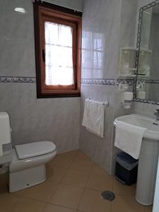 uma casa de banho com um WC e um lavatório em Hostal - Restaurante Casa Cuña em Tebra