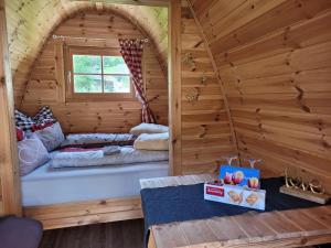 a room with a bed in a wooden cabin at Romantisches Holz-Iglu Optional mit Hotpot mit Whirlpoolfunktion und LED Unterwasserbeleuchtung in Neuhaus an der Eger
