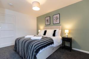 a bedroom with a bed with a black and white blanket at Jameson Lodge in Hartlepool
