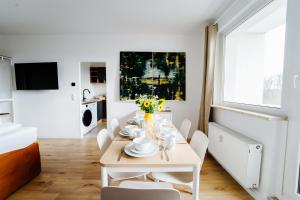 uma sala de jantar branca com uma mesa e cadeiras brancas em Jenapartments for7 Boxspring & Smart TV & Waschmaschine em Jena