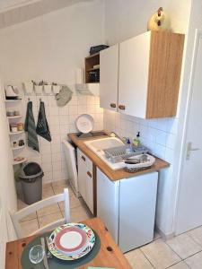 a small kitchen with a table and a counter top at Studio 11, Draps, Linge, Wifi # Longère Bretonne#Morbihan in Sulniac