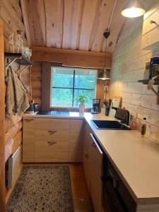 eine kleine Küche mit einem Waschbecken und einem Fenster in der Unterkunft Mökki luonnon keskellä. in Tervola