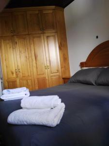 Zwei weiße Handtücher liegen auf einem Bett. in der Unterkunft CASA RURAL ACANTILADOS DE PAPEL in Morás