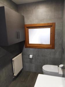 baño con aseo y ventana en CASA RURAL ACANTILADOS DE PAPEL, en Morás