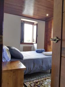 Schlafzimmer mit einem Bett und einem Fenster in der Unterkunft CASA RURAL ACANTILADOS DE PAPEL in Morás