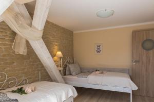 a bedroom with two beds and a brick wall at Penzion Na Palubě in Mikulovice