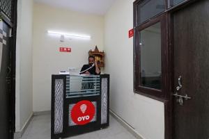 um homem sentado numa secretária num quarto em OYO Triage Home Stay em Noida
