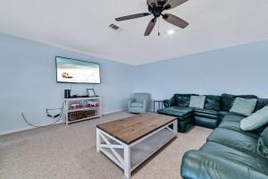 ein Wohnzimmer mit einer grünen Couch und einem Tisch in der Unterkunft Beach Energy in Gulf Shores