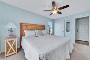 ein Schlafzimmer mit Bett und Deckenventilator in der Unterkunft Beach Energy in Gulf Shores + 33 Fotos