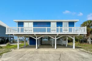 ein blaues Haus mit einer weißen Terrasse an einer Straße in der Unterkunft Beach Energy in Gulf Shores