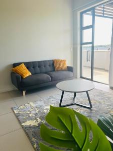 uma sala de estar com um sofá e uma mesa em Carlswald Apartments em Midrand