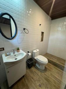 a bathroom with a toilet and a sink and a mirror at Green Paradise Bungalows in Las Palmas