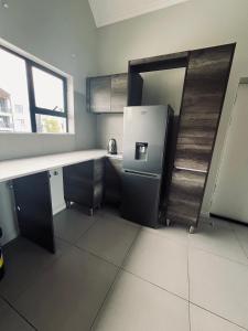 uma cozinha com um frigorífico e uma bancada em Carlswald Apartments em Midrand