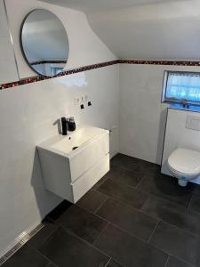 a bathroom with a white sink and a toilet at Cottage mit Garten in Michendorf
