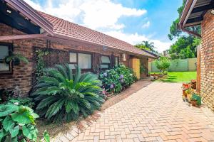 a brick house with a brick driveway in front of it at LeoZet Self catering apartment in Pretoria