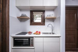 une cuisine avec un évier et un micro-ondes dans l'établissement Little Seaside Villa in Hersonissos, à Chersónissos