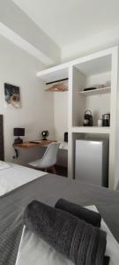 a bedroom with a bed and a table and a desk at Aegean Gold Syros Suites in Ermoupoli