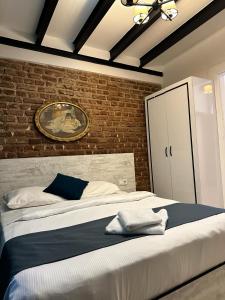ein Schlafzimmer mit einem großen Bett mit Ziegelwand in der Unterkunft VOLGAİSTANBUL in Istanbul