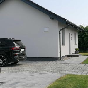 a car parked in front of a white building at Ferienhaus in Tupadły mit Grill und Terrasse in Jastrzębia Góra
