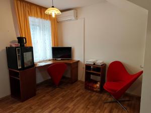 Cette chambre comprend un bureau avec un ordinateur et une chaise rouge. dans l'établissement Apartmaji Pri Kokolu, à Bled