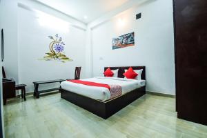 1 dormitorio con 1 cama con almohadas rojas en OYO Hotel Blue Lotus en Pushkar