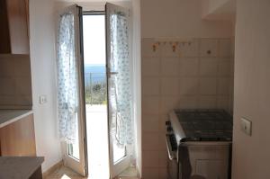 een keuken met een fornuis en een deur met een raam bij Poggio dei Venti in Monterotondo