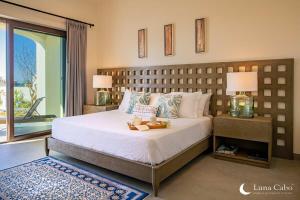a bedroom with a large bed with two lamps at Luxe Oceanview Villa with Pool Hot Tub BBQ and Fire Pit in San José del Cabo