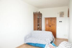een slaapkamer met een bed en een houten kast bij Poggio dei Venti in Monterotondo