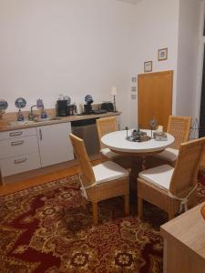 a living room with a table and chairs and a kitchen at Kurpension Parkfrieden in Bad Pyrmont