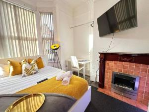 Schlafzimmer mit einem Bett, einem Kamin und einem TV in der Unterkunft Tranquil Haven Studio Escape in Vibrant Birmingham in Birmingham