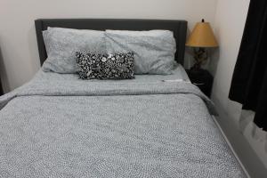 1 cama con edredón azul y 2 almohadas en Comfy basement near KW airport, en Kitchener