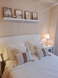 a bedroom with a white bed with white pillows at Casa del Sol in Manilva