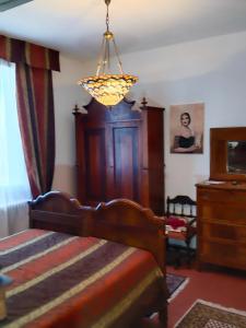 a bedroom with a bed and a chandelier at La Maison Rouge in Crespellano