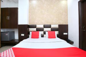 a bedroom with a large bed with red pillows at Hotel Winner Inn in Amritsar