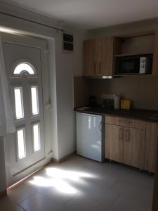 uma cozinha vazia com uma porta e uma janela em Zseli Apartmanház em Siófok